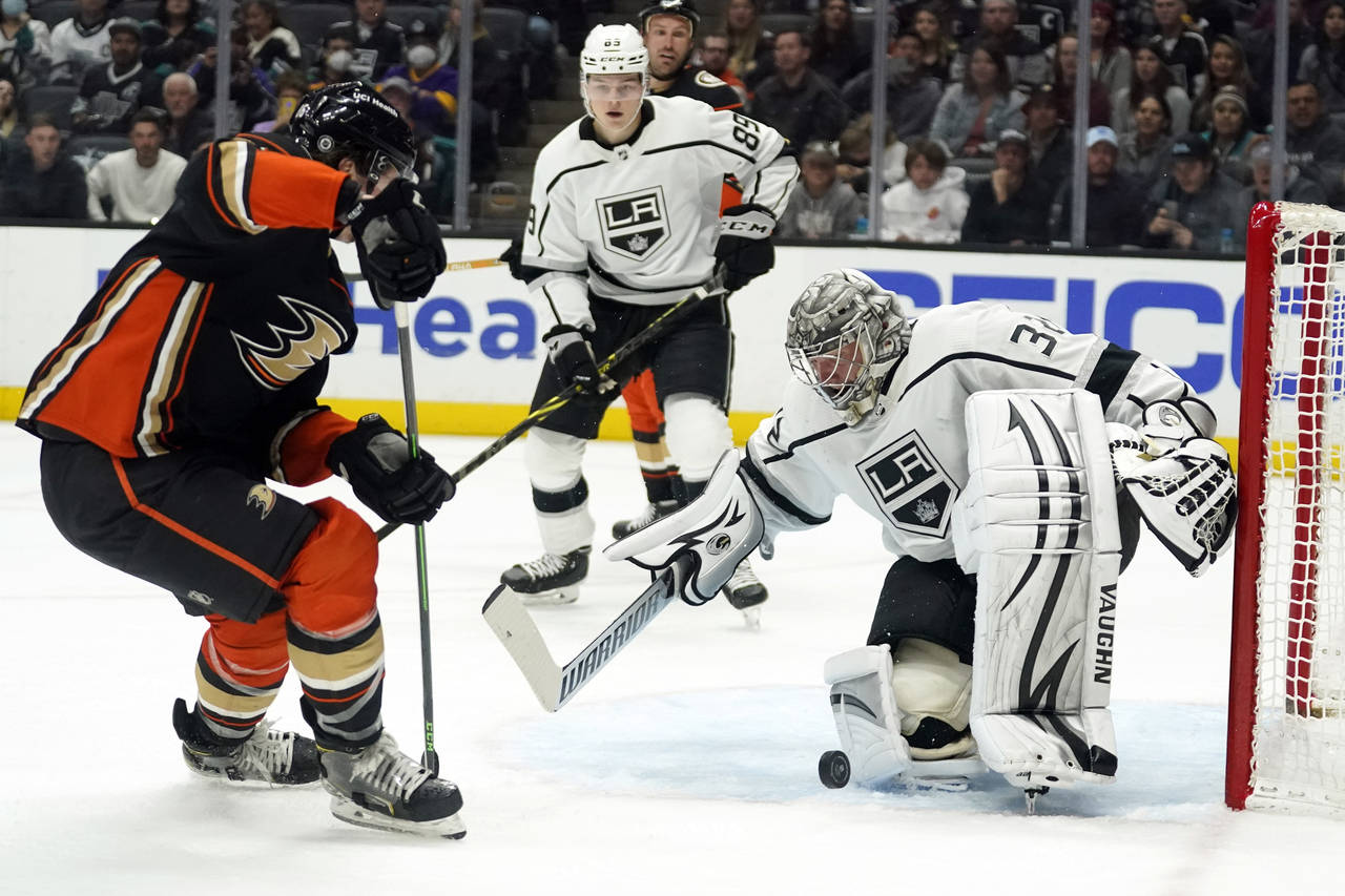 Los Angeles Kings goaltender Jonathan Quick, right, stops a shot during the second period of an NHL...