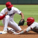
              Texas Rangers second baseman Marcus Semien (2) attempts a tag on Los Angeles Angels center fielder Mike Trout (27) who was safe for a double in the third inning of a baseball game, Sunday, April 17, 2022, in Arlington, Texas. (AP Photo/Richard W. Rodriguez)
            
