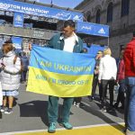 
              Igor Krytsak, of Kyiv, holds a Ukrainian flag, Sunday, April 17, 2022, while visiting the finish line of the Boston Marathon, in Boston. Krytsak planned to run the Boston Marathon after qualifying in London last year with a personal best 2 hours, 57 minutes, 33 seconds. After Russia invaded his homeland he could not leave the country without a special permit. Krytsak received permission to run in Boston for humanitarian purposes and arrived in the United States, Saturday, April 16. (Pat Greenhouse/The Boston Globe via AP)
            