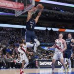 
              Dallas Mavericks center Dwight Powell (7) goes up to dunk between Portland Trail Blazers' Greg Brown III (4) and Drew Eubanks (24) during the first half of an NBA basketball game Friday, April 8, 2022, in Dallas. (AP Photo/Tony Gutierrez)
            