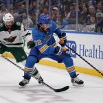 
              St. Louis Blues' Justin Faulk (72) and Minnesota Wild's Alex Goligoski (47) chase after a loose puck along the boards during the third period of an NHL hockey game Saturday, April 16, 2022, in St. Louis. (AP Photo/Jeff Roberson)
            