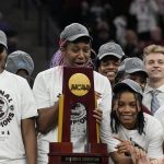 
              South Carolina's Aliyah Boston and teammates pose with the trophy after a college basketball game in the final round of the Women's Final Four NCAA tournament against UConn Sunday, April 3, 2022, in Minneapolis. South Carolina won 64-49 to win the championship. (AP Photo/Eric Gay)
            