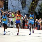
              Peres Jepchirchir, of Kenya, left, and Ababel Yeshaneh, of Ethiopia, clasp each others arms during the 126th Boston Marathon in Newton, Mass., Monday, April 18, 2022. Jepchirchir won the women's division and Yeshaneh finished second. At right is Joyciline Jeopkosgei, of Kenya. (AP Photo/Jennifer McDermott)
            