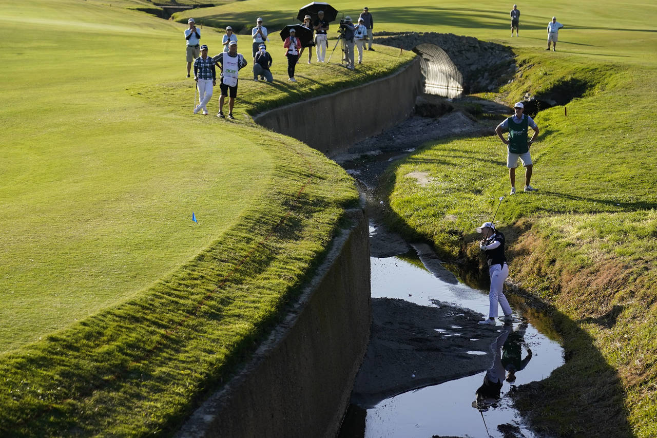 Jin Young Ko hits from a creek bed between the 17th and 18th holes during the third round of LPGA's...