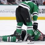 
              Dallas Stars center Luke Glendening checks on teammate Radek Faksa (12), who suffered an unknown leg injury when hit by the puck, in the first period of an NHL hockey game against the New York Islanders, Tuesday, April 5, 2022, in Dallas. (AP Photo/Tony Gutierrez)
            