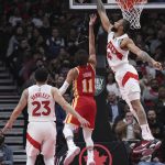 
              Toronto Raptors center Khem Birch (24) blocks a shot by Atlanta Hawks guard Trae Young's (11) during the first half of an NBA basketball game in Toronto on Tuesday, April 5, 2022. (Nathan Denette/The Canadian Press via AP)
            