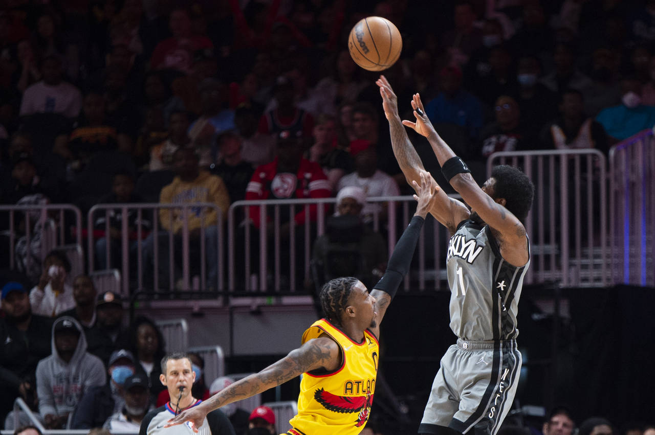 Brooklyn Nets guard Kyrie Irving (11) shoots a 3-point basket over Atlanta Hawks guard Delon Wright...