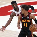 
              Atlanta Hawks guard Trae Young (11) tries to get past Miami Heat forward Jimmy Butler in the first half of an NBA playoff basketball game Sunday, April 24, 2022, in Atlanta. (AP Photo/John Bazemore)
            