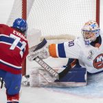 
              New York Islanders goaltender Ilya Sorokin, right, makes a stop against Montreal Canadiens' Jake Evans during third-period NHL hockey game action in Montreal, Friday, April 15, 2022. (Graham Hughes/The Canadian Press via AP)
            