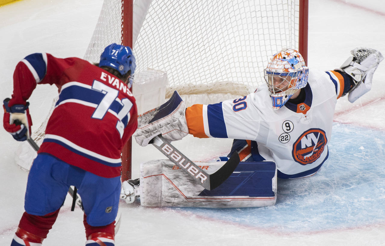 New York Islanders goaltender Ilya Sorokin, right, makes a stop against Montreal Canadiens' Jake Ev...