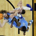 
              North Carolina forward Brady Manek, left and guard Caleb Love battle Kansas guard Christian Braun for a rebound during the first half of a college basketball game in the finals of the Men's Final Four NCAA tournament, Monday, April 4, 2022, in New Orleans. (AP Photo/David J. Phillip)
            
