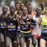 
              FILE - Benson Kipruto, of Kenya, front left, runs at the front an elite group of runners near CJ Albertson, of Fresno, Calif., front right, during the 125th Boston Marathon, Monday, Oct. 11, 2021, in Brookline, Mass. Kipruto won the men's division of the marathon. The Boston Marathon returns, Monday, April 18, 2022. (AP Photo/Steven Senne, File)
            