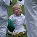 
              Mackenzie Hughes, of Canada's son Cohen sits on the night green during the Par 3 contest at the Masters golf tournament on Wednesday, April 6, 2022, in Augusta, Ga. (AP Photo/Robert F. Bukaty)
            