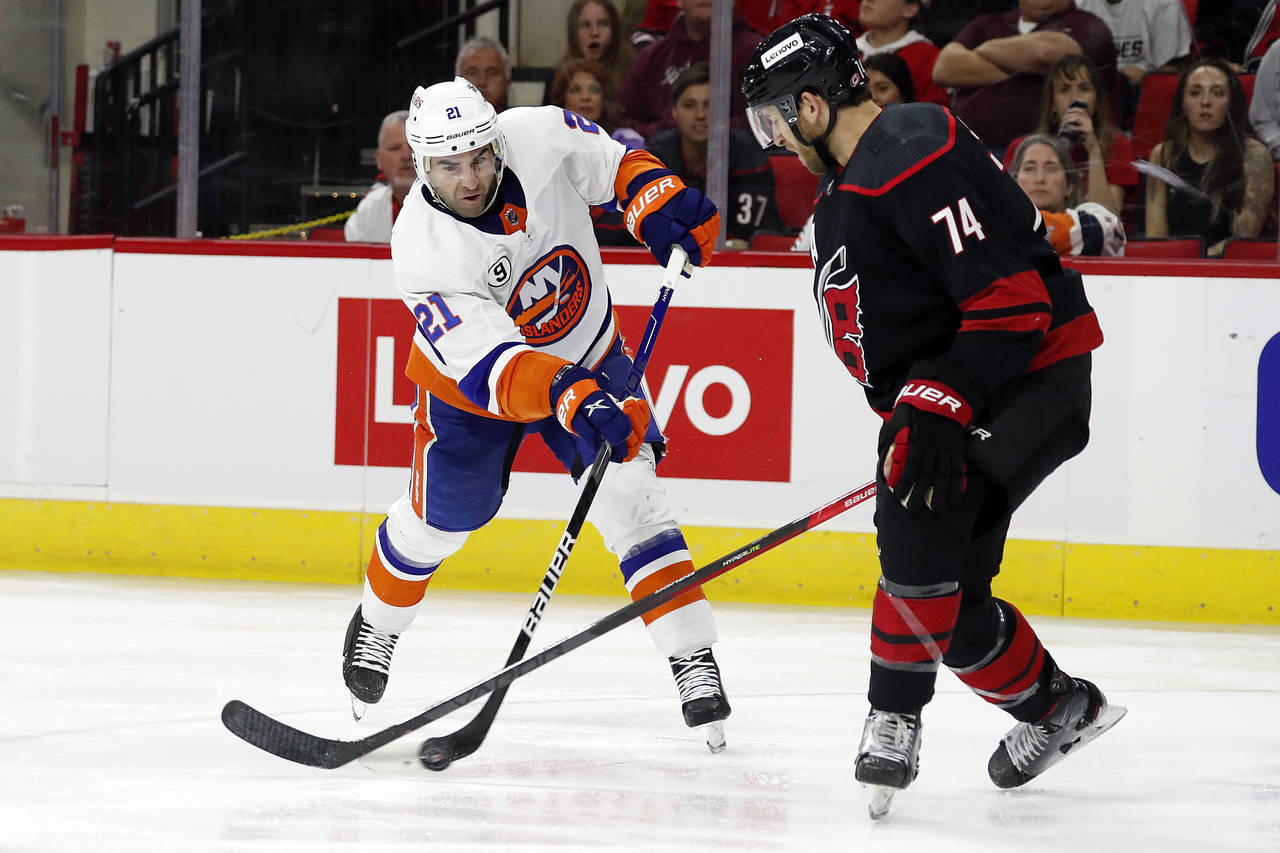 New York Islanders' Kyle Palmieri (21) tries to shoot the puck past Carolina Hurricanes' Jaccob Sla...