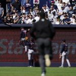 
              An umpire heads to left field as Cleveland Guardians' Oscar Mercado (35) restrains Myles Straw (7) during an altercation with fans during the ninth inning of a baseball game against the New York Yankees Saturday, April 23, 2022, in New York. The Yankees won 5-4. (AP Photo/Frank Franklin II)
            