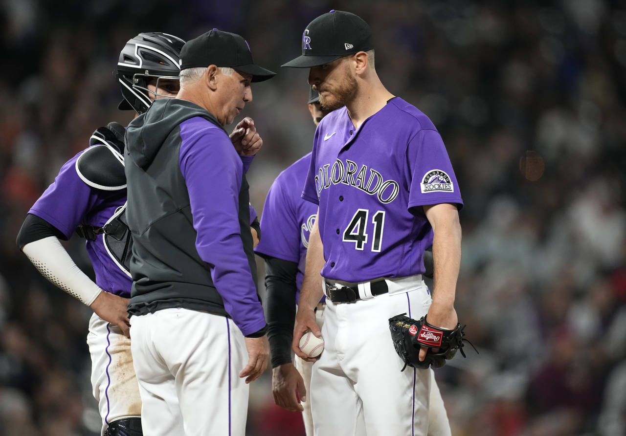 Colorado Rockies manager Bud Black, front left, pulls starting pitcher Chad Kuhl (41) after Kuhl ga...