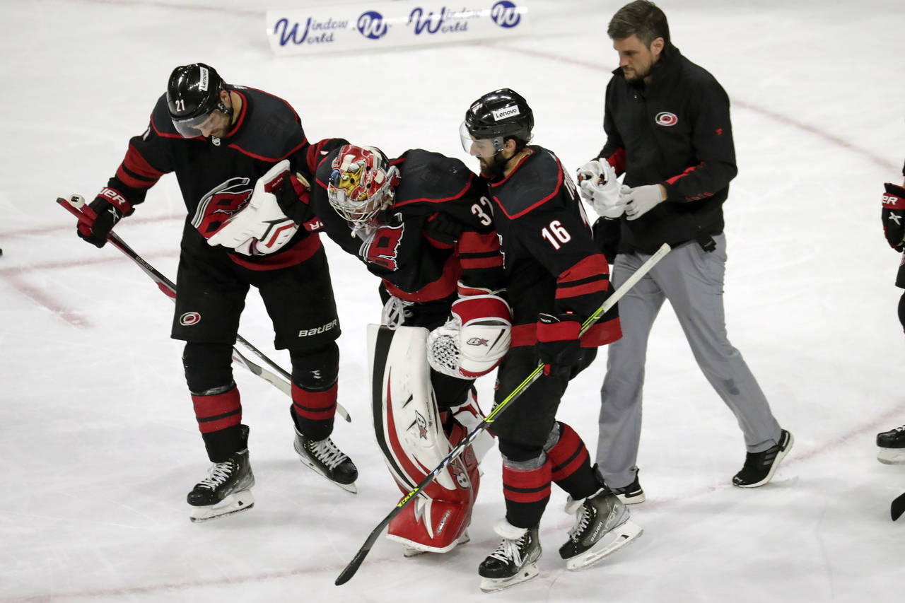 Carolina Hurricanes goaltender Antti Raanta (32) is helped off the ice by right wing Nino Niederrei...