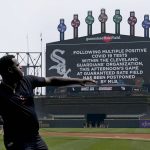 
              Cleveland Guardians' Franmil Reyes throws a football to teammate Myles Straw as the scoreboard informs fans that the baseball game between the Chicago White Sox and the Guardians has been postponed due to multiple positive COVID-19 tests within the Guardians organization, Wednesday, May 11, 2022, in Chicago. (AP Photo/Charles Rex Arbogast)
            