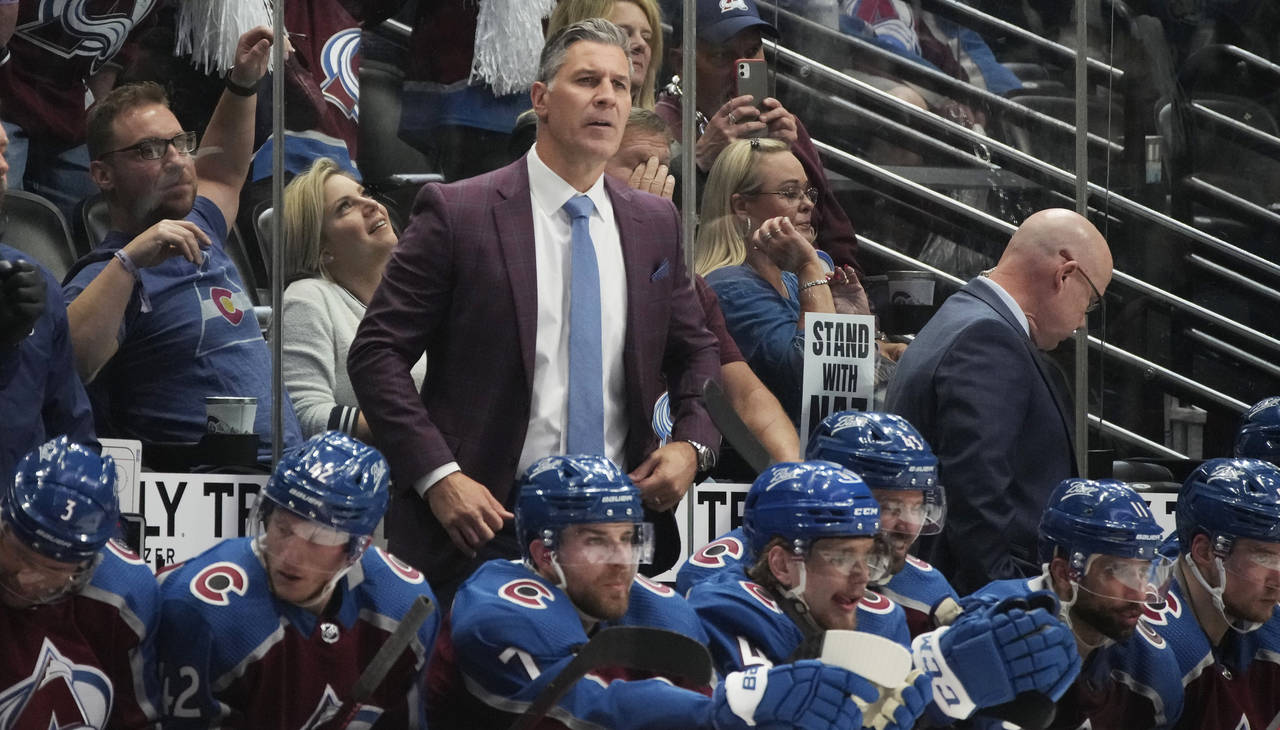 Colorado Avalanche coach Jared Bednar stands behind players on the bench during the second period o...