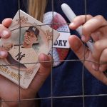 
              A fan holds a baseball card and a pen while waiting for autographs from New York Yankees' Aaron Judge before a baseball game between the Yankees and the Chicago White Sox in Chicago,Sunday, May 15, 2022. (AP Photo/Nam Y. Huh)
            