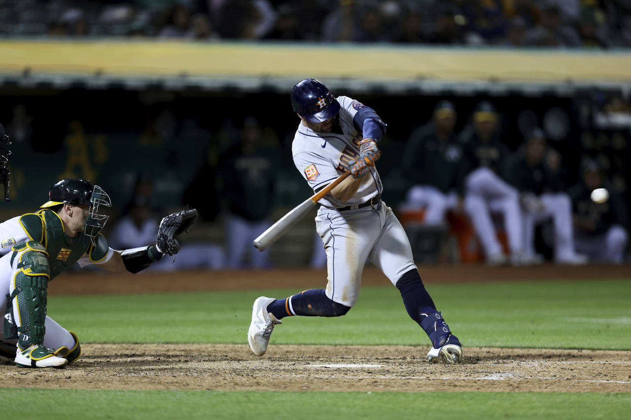 Houston Astros' Chas McCormick hits a home run in front of Oakland Athletics catcher Sean Murphy du...