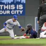 
              Minnesota Twins' Jose Miranda, center, is safe at second base after hitting a double as Kansas City Royals second baseman Nicky Lopez can't hang on to the ball to make the tag, while umpire Adam Beck watches during the fourth inning of a baseball game Thursday, May 26, 2022, in Minneapolis. (AP Photo/Craig Lassig)
            
