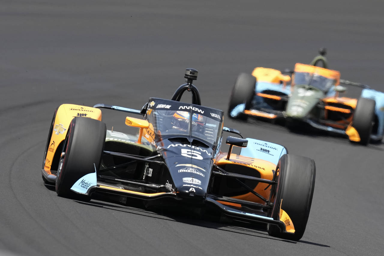 Pato O'Ward, of Mexico, drives into the first turn during the Indianapolis 500 auto race at Indiana...