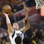 
              Dallas Mavericks guard Luka Doncic, left, shoots against Golden State Warriors center Kevon Looney during the first half of Game 1 of the NBA basketball playoffs Western Conference finals in San Francisco, Wednesday, May 18, 2022. (AP Photo/Jed Jacobsohn)
            