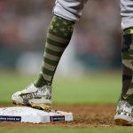 
              Detroit Tigers' Jeimer Candelario stands on first base wearing the Armed Forces Day socks during the seventh inning of a baseball game against the Cleveland Guardians, Friday, May 20, 2022, in Cleveland. (AP Photo/Ron Schwane)
            