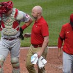 
              Cincinnati Reds catcher Tyler Stephenson, left, is helped by a team trainer as he leaves the team's baseball game against the Pittsburgh Pirates with an injury during the third inning in Pittsburgh, Saturday, May 14, 2022. (AP Photo/Gene J. Puskar)
            