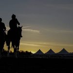 
              Horse trainer D. Wayne Lukas, left, rides atop Riff as he helps exercise rider Oscar Quevedo and Preakness entrant Secret Oath onto the track for a morning workout ahead of the Preakness Horse Race at Pimlico Race Course, Wednesday, May 18, 2022, in Baltimore. Lukas believes Secret Oath could be one of the best fillies he has ever had. That belief and her winning the Kentucky Oaks in impressive fashion the day before the Derby inspired him to enter Secret Oath in the Preakness Stakes, where she could give the 86-year-old Hall of Fame trainer a record-tying seventh victory in the second jewel of the Triple Crown. (AP Photo/Julio Cortez)
            