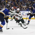 
              Minnesota Wild's Mats Zuccarello (36) lunges for the puck between St. Louis Blues' Ryan O'Reilly (90) and Brandon Saad (20) during the second period in Game 3 of an NHL hockey Stanley Cup first-round playoff series Friday, May 6, 2022, in St. Louis. (AP Photo/Michael Thomas)
            