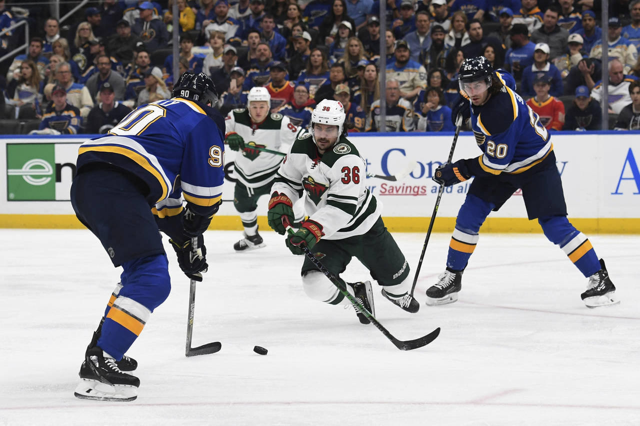 Minnesota Wild's Mats Zuccarello (36) lunges for the puck between St. Louis Blues' Ryan O'Reilly (9...