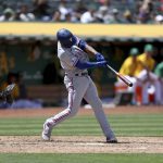 
              Texas Rangers' Marcus Semien, right, hits a grand slam in front of Oakland Athletics catcher Christian Bethancourt, left, during the fifth inning of a baseball game in Oakland, Calif., Saturday, May 28, 2022. (AP Photo/Jed Jacobsohn)
            