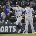 Tampa Bay Rays' Brandon Lowe celebrates with third-base coach Rodney Linares after hitting a home run during the fourth inning of the team's baseball game against the Seattle Mariners, Saturday, May 7, 2022, in Seattle. (AP Photo/Jason Redmond)