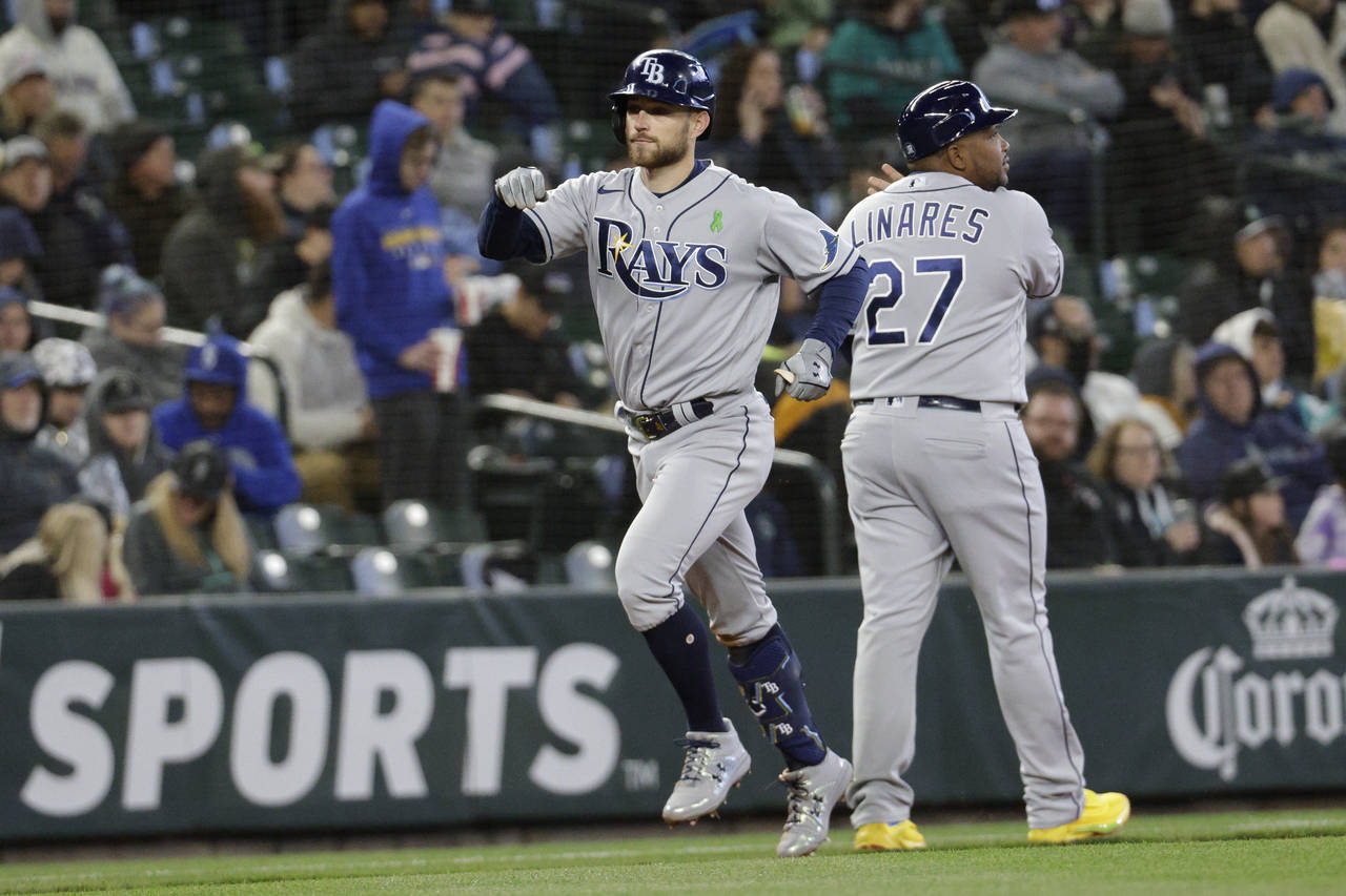 Tampa Bay Rays' Brandon Lowe celebrates with third-base coach Rodney Linares after hitting a home r...