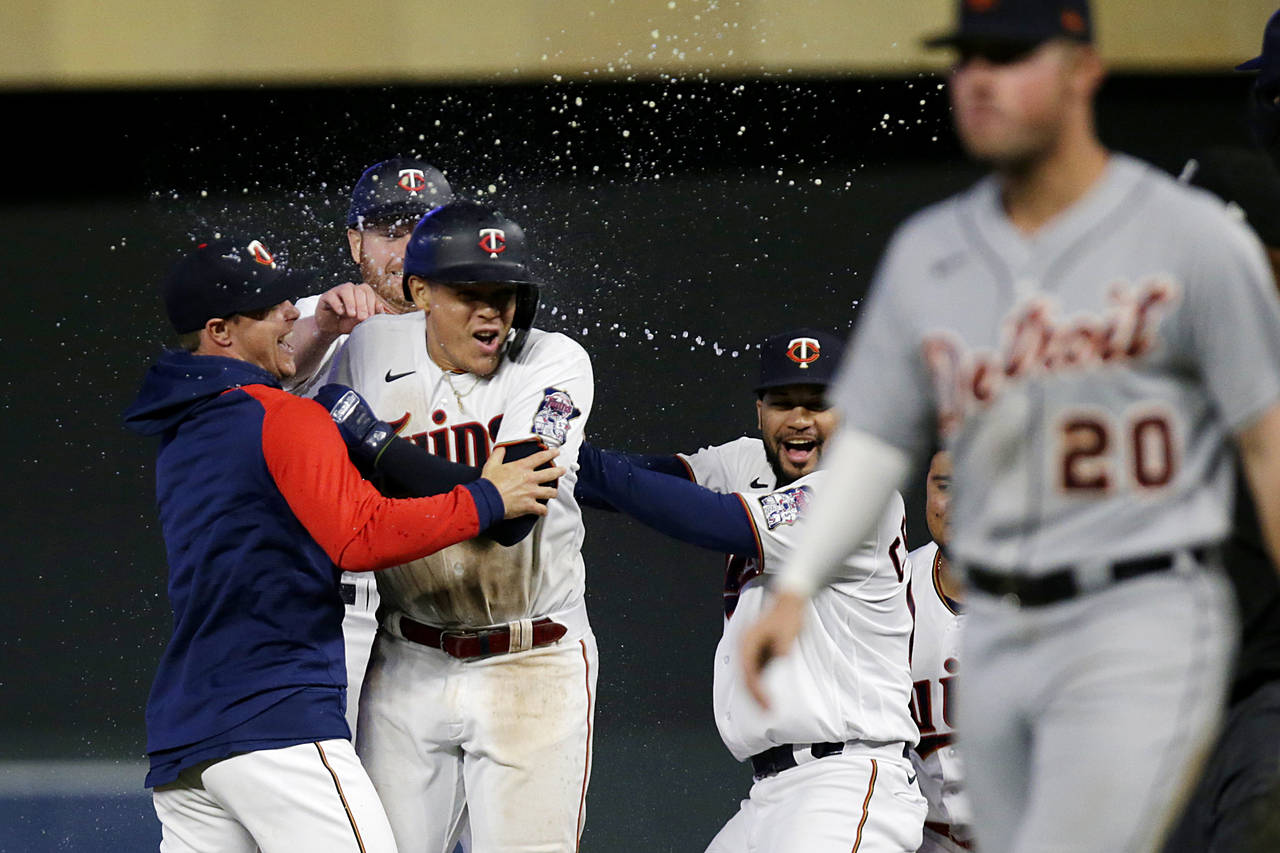 Minnesota Twins third baseman Gio Urshela, center, is congratulated by teammates for a game-winning...