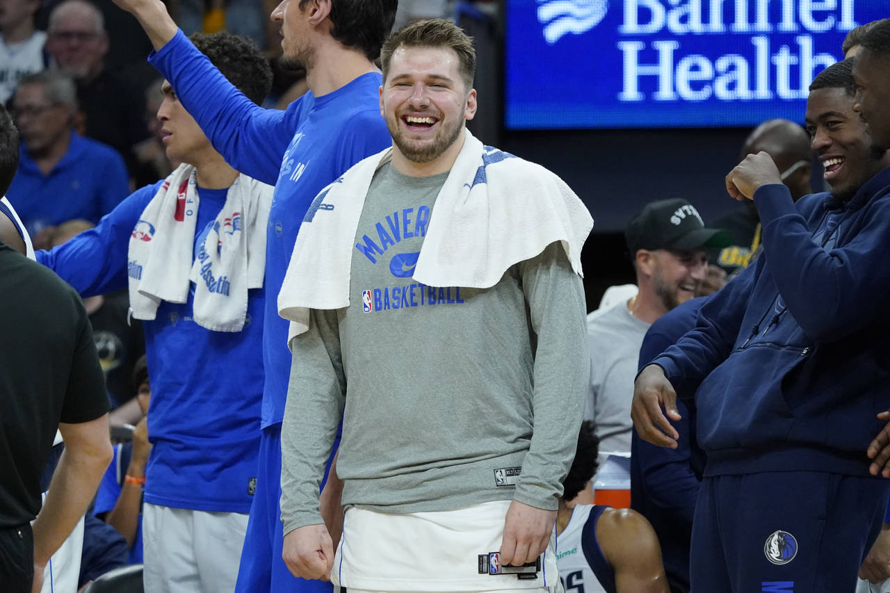 Dallas Mavericks guard Luka Doncic smiles on the bench during the second half of Game 7 of an NBA b...