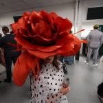 
              Brittany McKewn, of Asheville, NC, wears a hat shaped like a rose before the 148th running of the Kentucky Derby horse race at Churchill Downs Saturday, May 7, 2022, in Louisville, Ky. (AP Photo/Charlie Riedel)
            