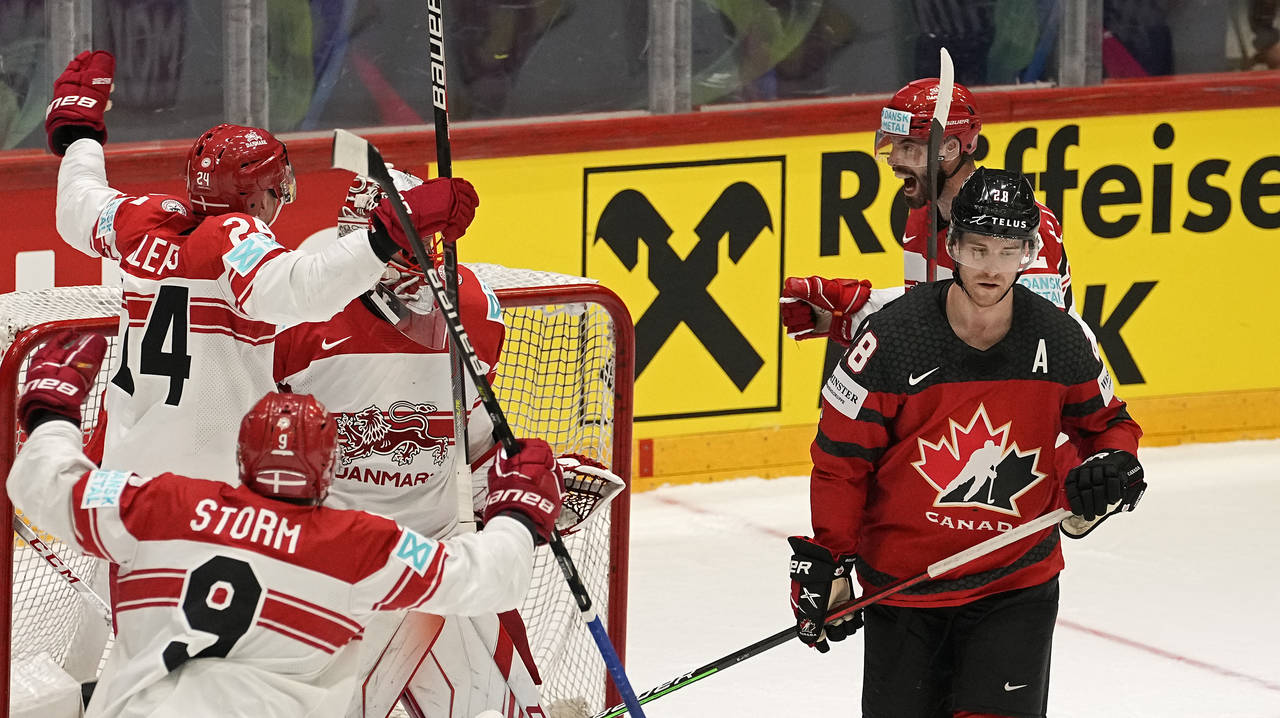 Denmark's players celebrate beside Canada's Damon Severson, right, after winning the group A Hockey...
