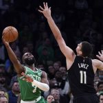 
              Boston Celtics guard Jaylen Brown, left, shoots while pressured by Milwaukee Bucks center Brook Lopez (11) during the first half of Game 2 of an Eastern Conference semifinal in the NBA basketball playoffs Tuesday, May 3, 2022, in Boston. (AP Photo/Charles Krupa)
            