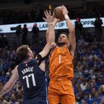 
              Dallas Mavericks guard Luka Doncic (77) defends against a shot by Phoenix Suns guard Devin Booker (1) in the first half of Game 4 of an NBA basketball second-round playoff series, Sunday, May 8, 2022, in Dallas. (AP Photo/Tony Gutierrez)
            