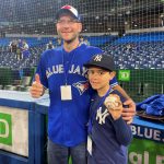 
              Nine-year-old Derek Rodriguez poses for a photo Wednesday, May 4, 2022, in Toronto with Mike Lanzillotta, the Toronto Blue Jays fan who caught the ball on a home run by New York Yankees' Aaron Judge on Tuesday and handed it to Derek. On Wednesday, Judge signed the ball and met Derek before the game. (Gregory Strong/The Canadian Press via AP)
            