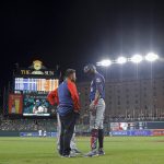 
              A trainer talks to Minnesota Twins' Carlos Correa, right, after he was hit by a pitch from Baltimore Orioles starting pitcher Spenser Watkins during the fifth inning of a baseball game, Thursday, May 5, 2022, in Baltimore. (AP Photo/Julio Cortez)
            