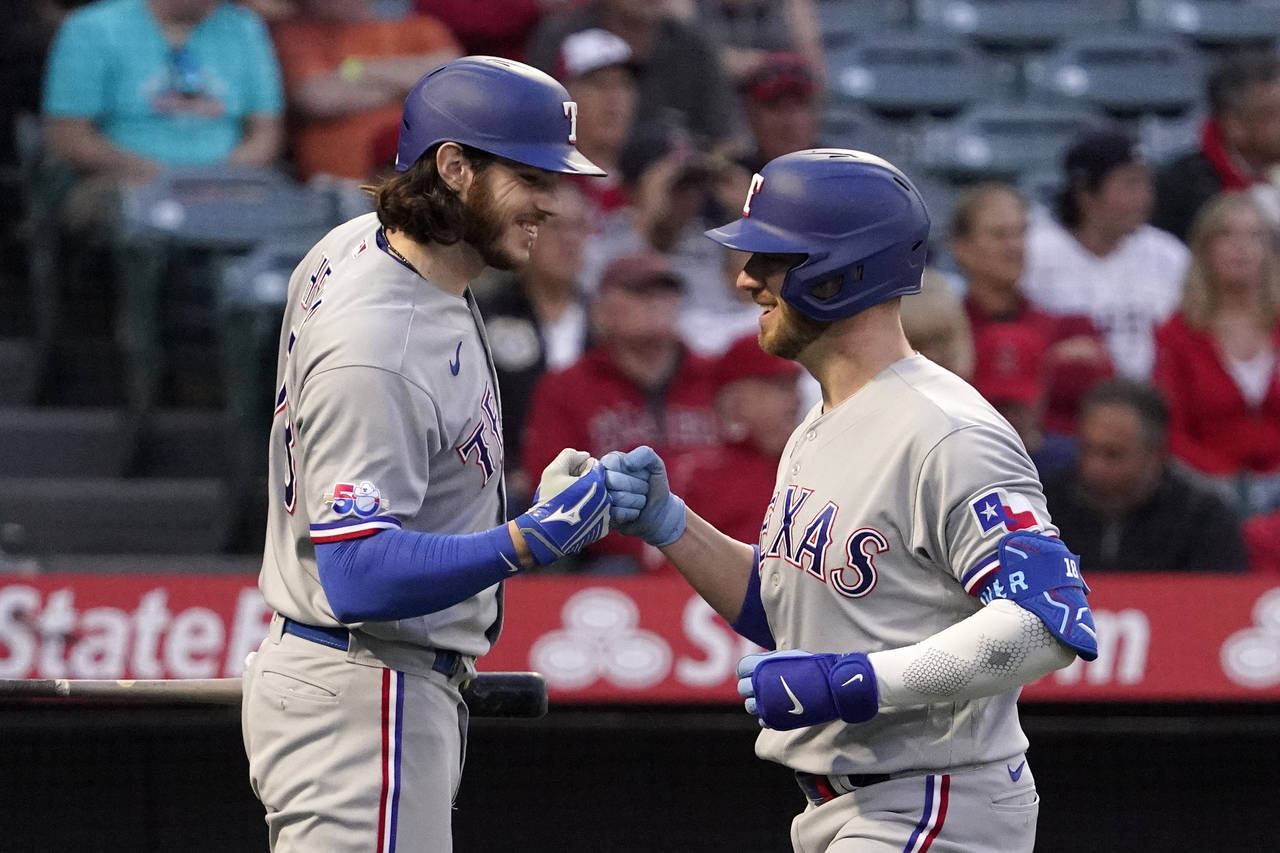 Texas Rangers' Mitch Garver, right, is congratulated by Jonah Heim after hitting a solo home run du...