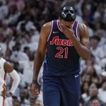 
              Philadelphia 76ers center Joel Embiid (21) wipes his face during the second half of Game 5 of an NBA basketball second-round playoff series against the Miami Heat, Tuesday, May 10, 2022, in Miami. (AP Photo/Wilfredo Lee)
            