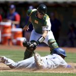 
              Oakland Athletics catcher Sean Murphy, top, tags out Texas Rangers' Andy Ibanez, bottom, on a fielder's choice hit into by Eli White during the seventh inning of a baseball game in Oakland, Calif., Sunday, May 29, 2022. (AP Photo/Jed Jacobsohn)
            