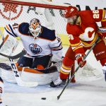 
              Edmonton Oilers goalie Mike Smith, left, blocks a shot from Calgary Flames forward Elias Lindholm during the second period of Game 2 of an NHL hockey Stanley Cup playoffs second-round series Friday, May 20, 2022, in Calgary, Alberta. (Jeff McIntosh/The Canadian Press via AP)
            