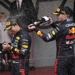 
              Red Bull driver Sergio Perez of Mexico, left, celebrates with his teammate third placed Red Bull driver Max Verstappen on the podium as Team chief Christian Horner of Red Bull Racing sprays champagne on his head after winning the Monaco Formula One Grand Prix, at the Monaco racetrack, in Monaco, Sunday, May 29, 2022. (AP Photo/Daniel Cole)
            