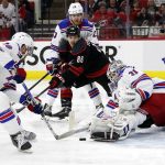 
              Carolina Hurricanes' Teuvo Teravainen (86) drives the puck between New York Rangers' Adam Fox (23) and Andrew Copp (18) to shoot at goaltender Igor Shesterkin (31) during the second period of Game 5 of an NHL hockey Stanley Cup second-round playoff series in Raleigh, N.C., Thursday, May 26, 2022. (AP Photo/Karl B DeBlaker)
            